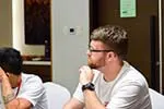 A photo of a man listening closely to the speaker